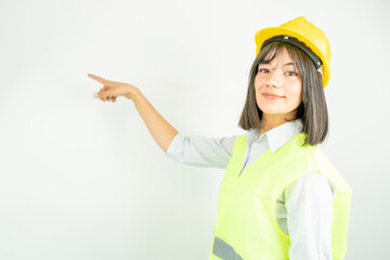 Woman architect or engineer wearing industrial helmet pointing with finger. Isolated female portrait.