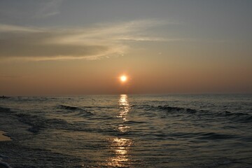 Serene ocean sunset with gentle waves.