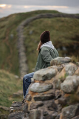Woman tourist with Hadrian's wall on the background, happy Traveler travel Northumberland, United Kingdom. Destination and Vacation
