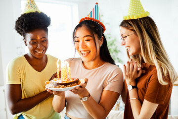 birthday celebration party cake happy candle blowing friendship fun friend woman home smiling...