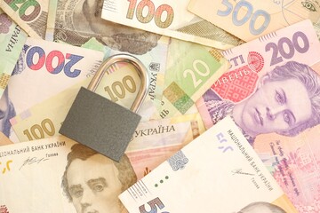 Many ukrainian money bills and small black padlock.