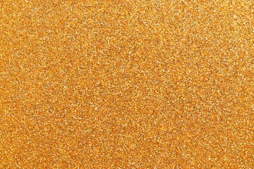 Beautiful golden glitter sparks texture as background with shallow depth of field