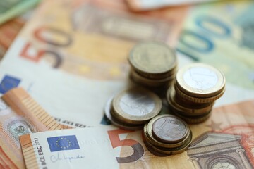 Stacks of euro cent coins lien on big amount of euro banknotes