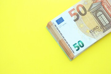 Big amount of one hundred and fifty euro money bills on yellow background