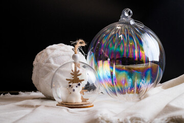White, blue and glass christmas balls on fabrics with black backgrond