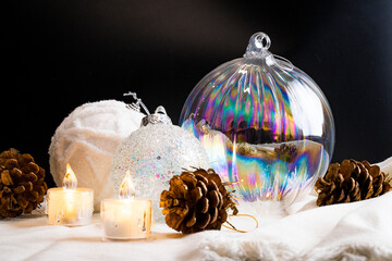 White, blue and glass christmas balls on fabrics with black backgrond