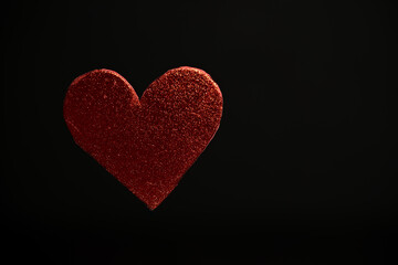 Figura de corazón roja flotando con fondo negro