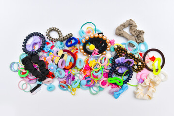 Colorfull pile of elastic bands, pins, clips and ties for hair on white background.