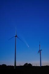 Comet C/2023 A3 Tsuchinshan-ATLAS in the night sky between two wind turbines