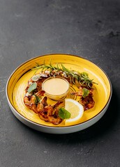 Grilled shrimp with dipping sauce and fresh herbs on a vibrant plate, seafood and gourmet lovers
