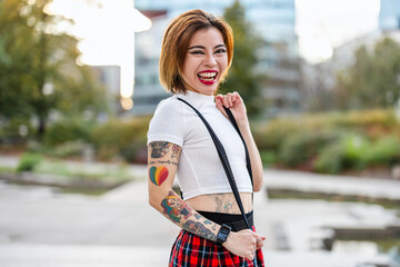 Beautiful young woman with tattoos on her arms smiling in the city
Portrait of a smiling young woman in the city
