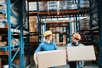 Warehouse workers carrying boxes and smiling at each other