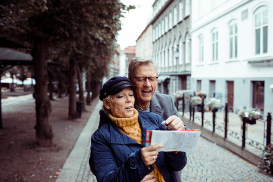 Senior mature couple exploring city with map - Powered by Adobe