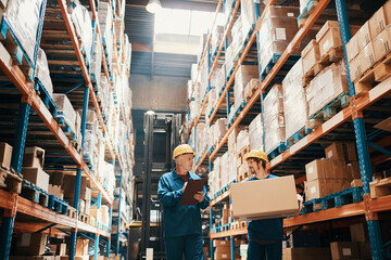 Supervisor and warehouse worker discussing logistics while checking inventory