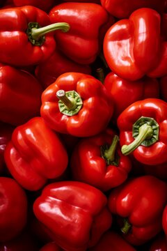 A close-up shot of a pile of fresh red bell peppers.