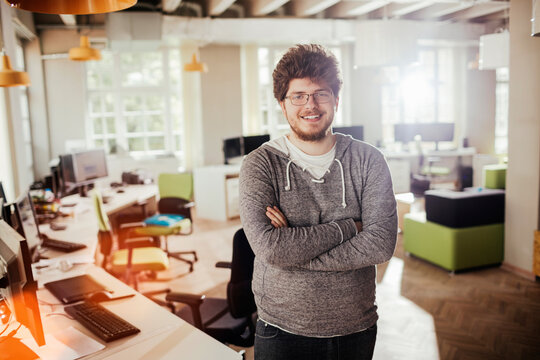 Portrait of a young man working in a startup company office and looking at the camera
