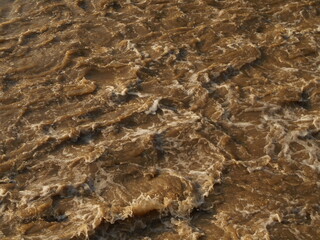 Choppy, muddy, brown river water.