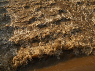Choppy, muddy, brown river water.