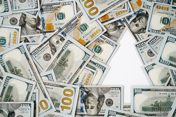 Creative concept of a negative space Christmas tree made from U.S. one-hundred-dollar bills arranged with an empty, tree-shaped space in the right. This unique flat lay design of happy new year. 