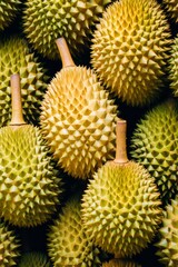 Close-up of durian fruits with spiky green rinds arranged in a pile.