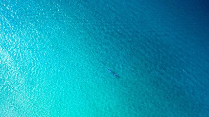 Paddle board, travel and aerial of people in sea for adventure, journey and water sports in Malaysia. Blue ocean, space and drone of friends on summer vacation, holiday and explore on tropical island