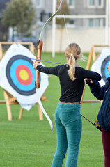 A young woman learnis the basics of archery