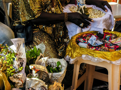 Mother of Candomble saint holds a basket with popcorn and the image of Saint George (Ogum) in front of the Church