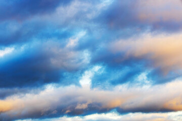 Obraz premium Close-up view of colorful clouds in dramatic sky, with soft hues of blue and orange during sunset or sunrise.