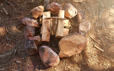 Forest, wood and bonfire for camping with adventure, explore and survival. Outdoor, from above and fire pit with rocks for warming or barbecue and cooking at site in nature with traveling and gather