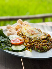 Close up of Indonesian Fried Noodles with fried egg and prawn crackers