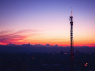 Obraz premium Telecom tower silhouette against a colorful sunrise sky, technology, red