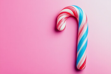 Colorful Candy Cane with Red and Blue Stripes Against a Soft Pink Background, Perfect for Holiday, Christmas, or Festive Themed Designs and Decorations