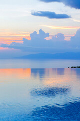 Fototapeta premium a contemporary seaside villa with infinity pool reflecting sunset