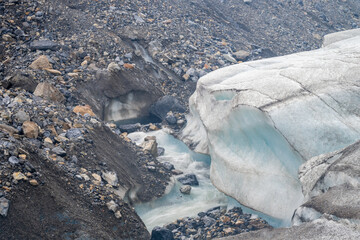 Snow and rock edge of the Athabasca Glacier in Jasper National Park where meltwater flows off the ice
