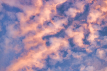 A beautiful sky tinted by the sun leaving vibrant shades of gold, pink, blue and multicolored. Clouds in the twilight evening and morning sky. Cloudy sky background in the evening, and during the day.