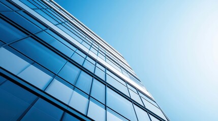 Obraz premium Modern skyscraper reflecting blue sky and sunlight
