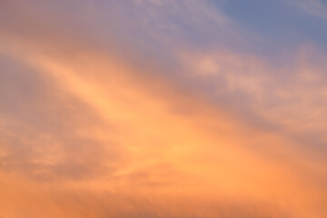 A beautiful sky tinted by the sun leaving vibrant shades of gold, pink, blue and multicolored. Clouds in the twilight evening and morning sky. Cloudy sky background in the evening, and during the day.