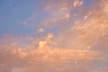 A beautiful sky tinted by the sun leaving vibrant shades of gold, pink, blue and multicolored. Clouds in the twilight evening and morning sky. Cloudy sky background in the evening, and during the day.