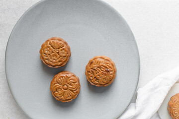 homemade mooncakes on a grey plate, top view of baked mooncakes on a plate, process of making mooncakes for Lunar New Year and mid autumn festival