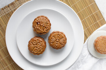 Overhead view of homemade mooncakes, top view of baked mooncakes on white plate, process of making mooncakes for Lunar New Year and mid autumn festival