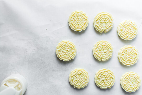 Overhead view of tuwon madara on white parchment paper, nigerian alawar madara milk candy, top view of milk fudge on a white background