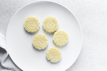 Overhead view of tuwon madara on a white plate, nigerian alawar madara milk candy, top view of milk fudge on a white ceramic plate