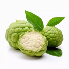 Fototapeta premium Three green cherimoya fruits with one cut open, showcasing its creamy interior and leaves.