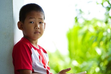 A Thai boy smiles with a cute face and a happy expression.