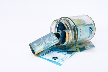 fifty thousand rupiah notes dropped in a clear jar