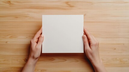 Fototapeta premium Blank card held by two hands over a table with subtle lighting, Card held by hands over table, Personal and natural