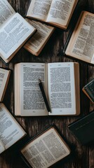 Obraz premium A collection of open books and a pen arranged on a wooden surface.