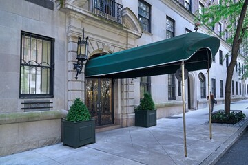 Manhattan sidewalk with awning above entrance to apartment building