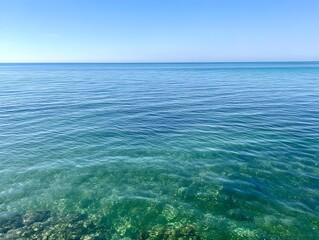 Fototapeta premium Calm ocean water glistening with sparkles in deep greens and blues reflecting the serene tranquility of the sea