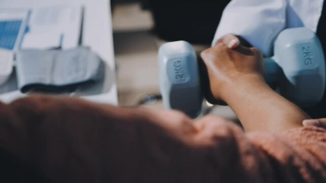 Asian woman physiotherapist oversees the patient&rsquo;s exercise.